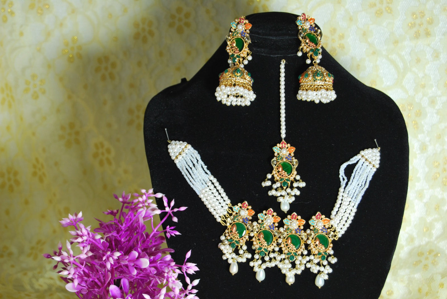 jadau choker jewelry set with green and multi kundan stones and pearls.